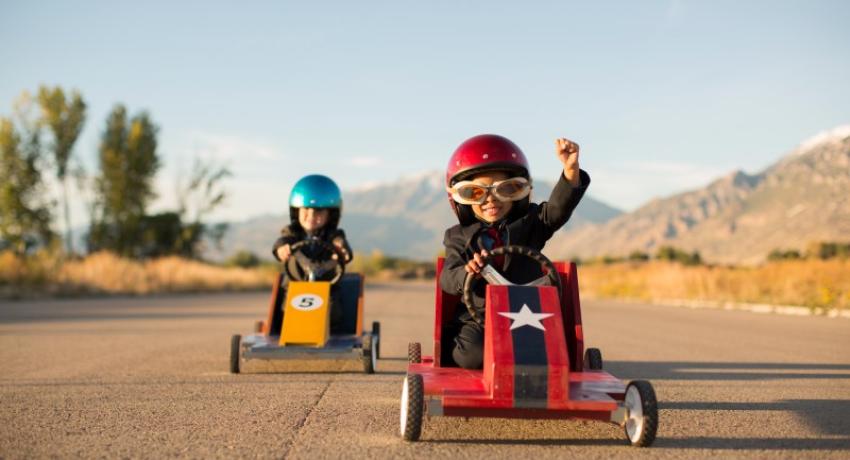 children racing in homemade cars